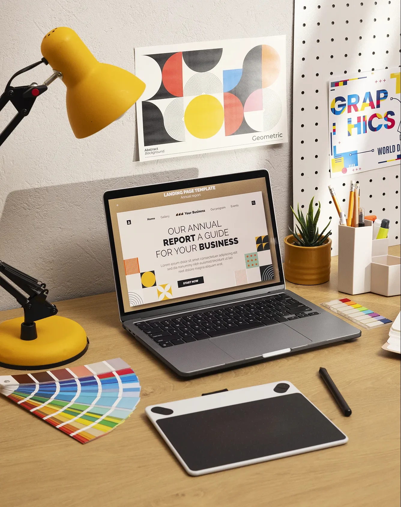 A colorful image with a side view of an office with a yellow desk lamp, a laptop showing a landing page template design and a stylus pen in front of the laptop